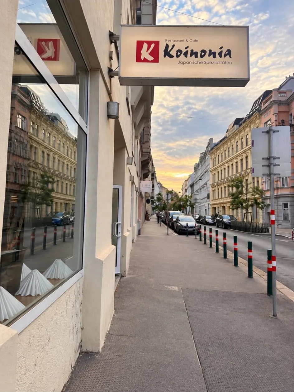 Der beleuchtete Schriftzug des Restaurant Koinonia an der Hausfassade in der Klostergasse, im Abendlicht