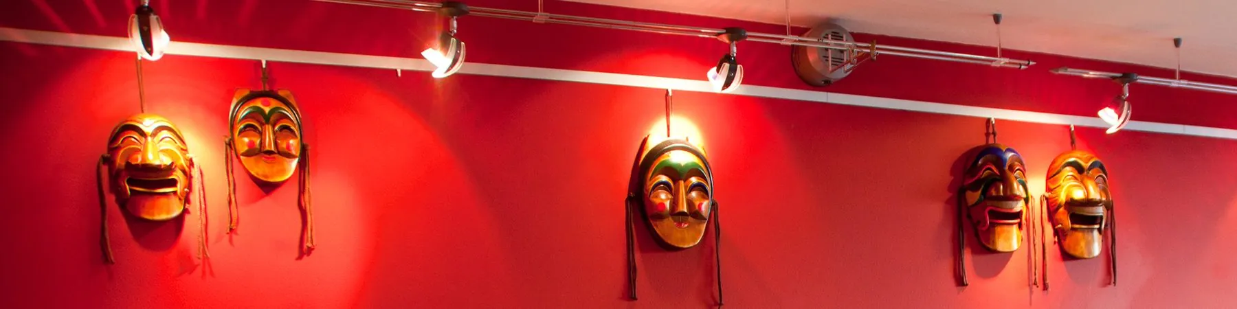Traditionelle koreanische Masken an der roten Wand des Lokals