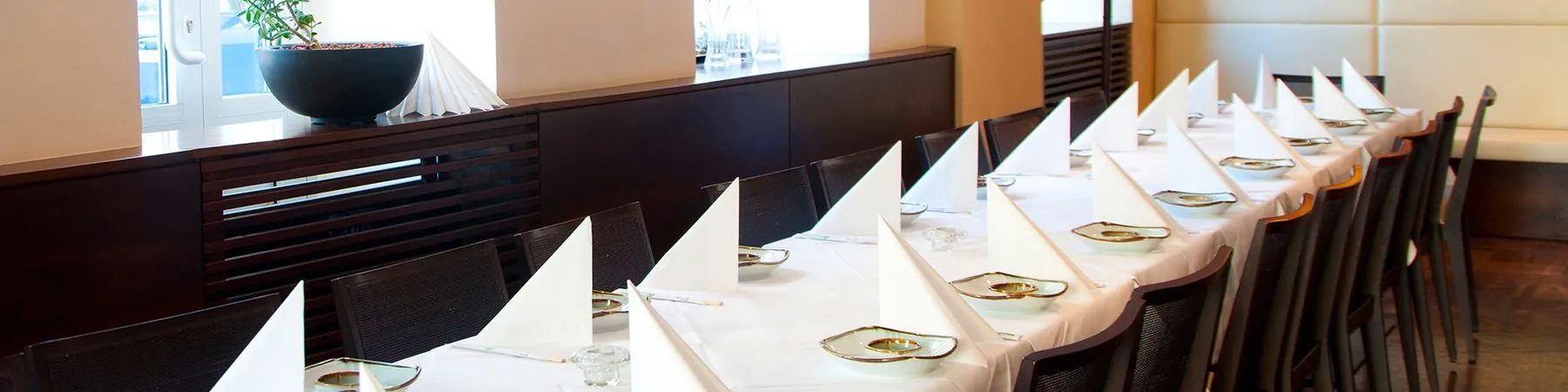 Eingedeckte Tafel mit weißer Tischdecke und gefalteten Servietten